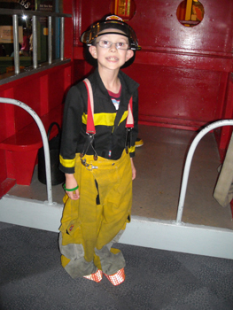 Boy dressed in fireman's attire during Center for Autism and Related Disabilities activity