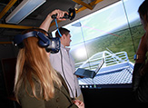 UAlbany graduate research assistant Vanessa Przybylo rides a virtual reality roller coaster in the xCITE Lab.
