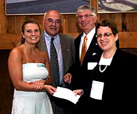 Ashley Fitch, Class of 2004, and M. Dolores Cimini, director of Middle Earth, are presented with a check for $10,000 from Dennis Sugumele of the Dominion Foundation (back row, right) as James P. Doellefeld, vice president for Student Affairs looks on.