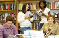 Tom Ringwood, Sarah Tsang, and Shannon William pick up copies of the Reading Project's "Field Notes from a Catastrophe" from Officer in Charge Susan Herbst