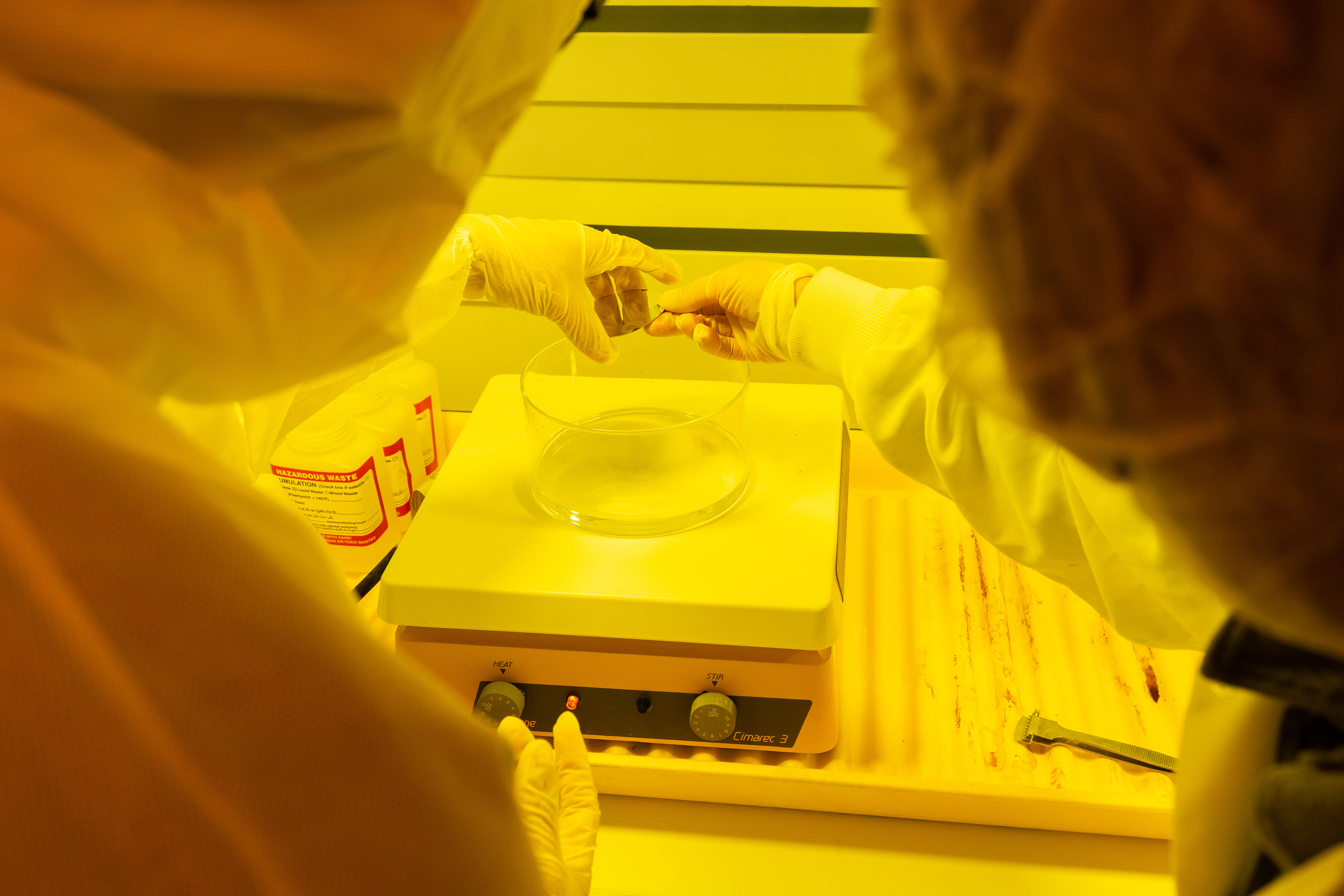 Two individuals in white lab coats participate in a cleanroom tour as part of the University at Albany's semiconductor program.