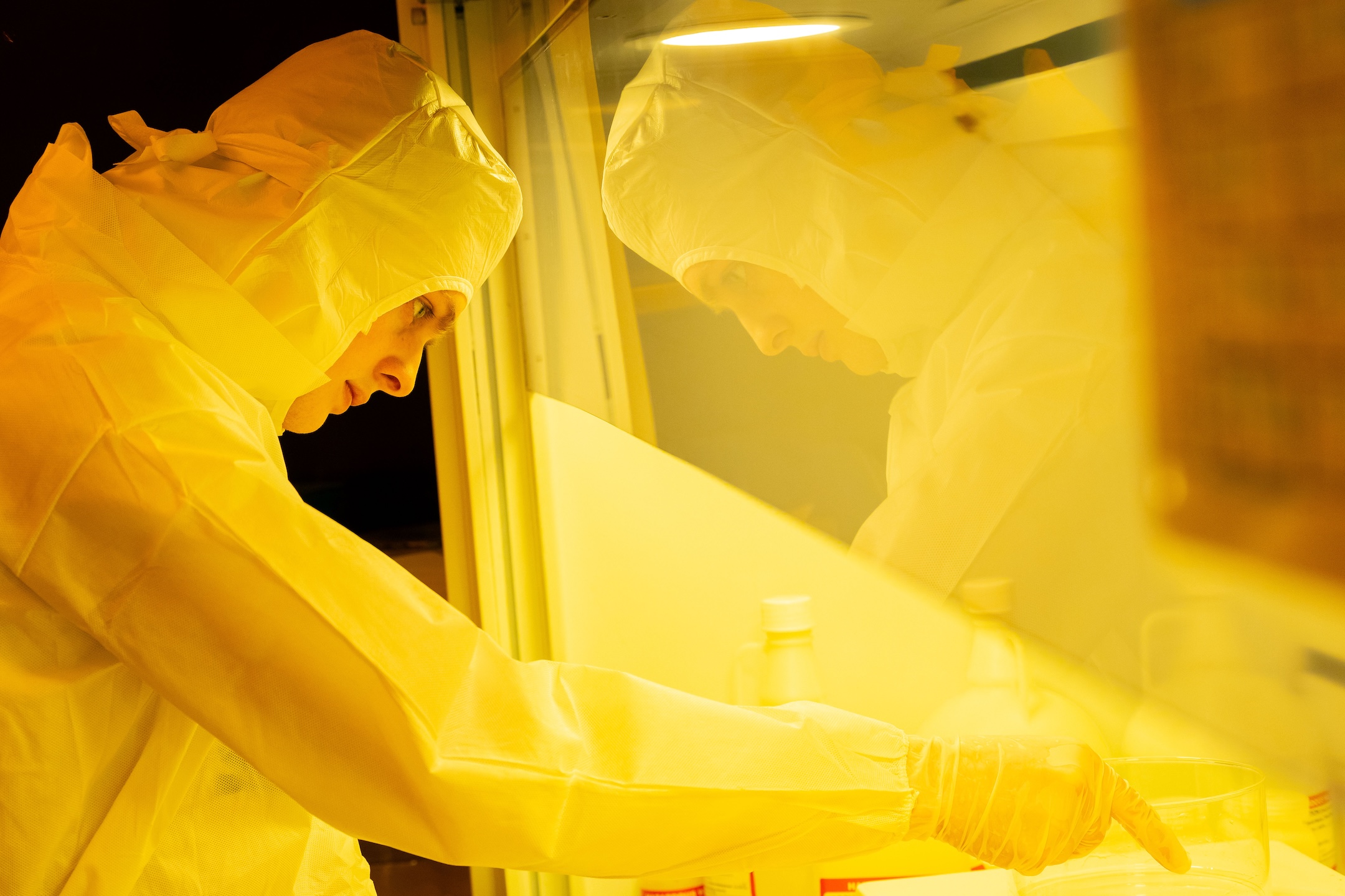 Student in protective bunny suit works in Innovation Lab. 