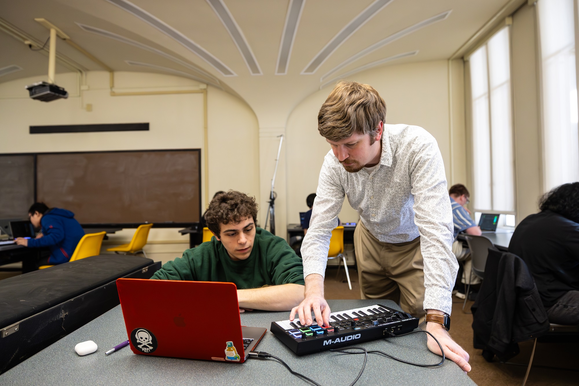 Thomas Wilson uses a MIDI keyboard to interact with a student in his game design course.