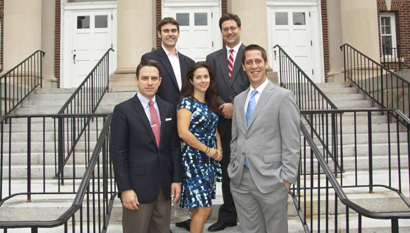 Five members of the PISCES team pose for a photo on a staircase in front of a building.