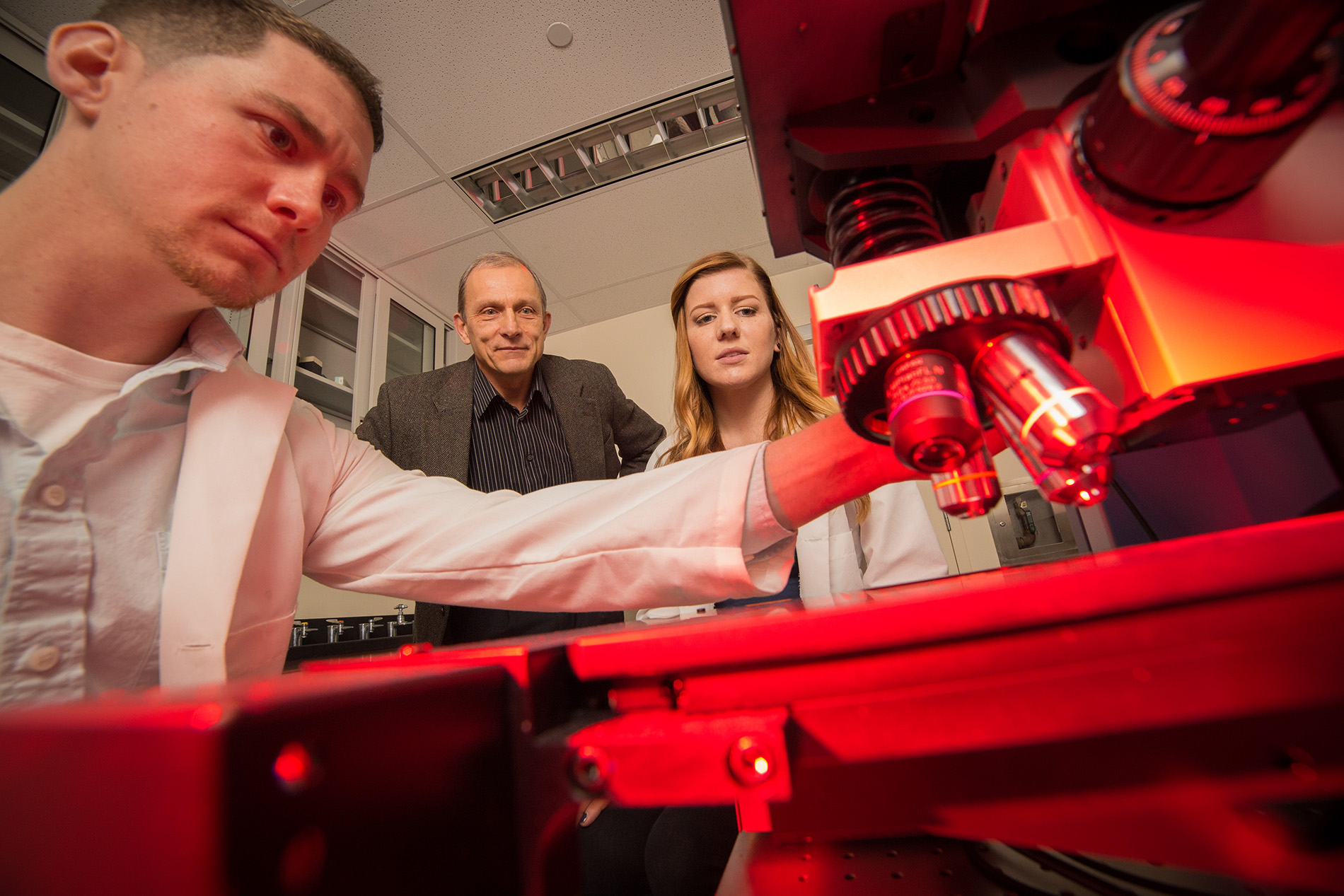 Igor Lednev and graduate students in his lab shine a laser on a dry sample.
