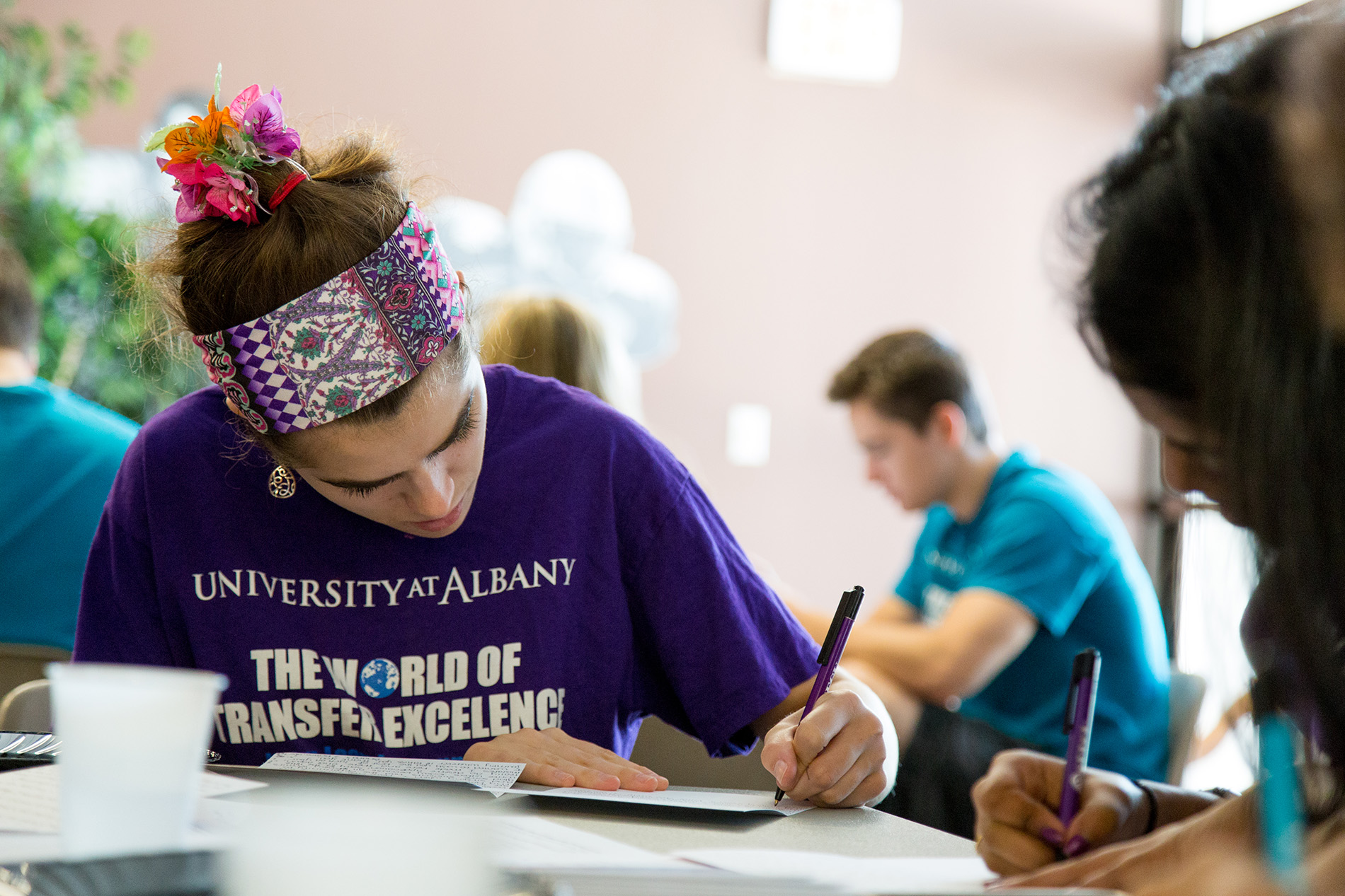 A student writes in a notebook during a living-learning community service day