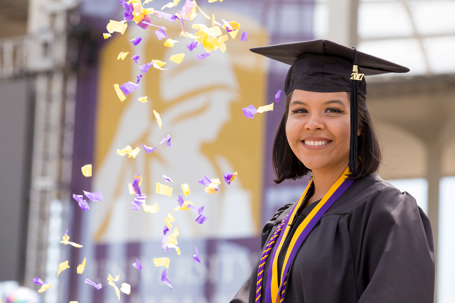 UAlbany graduate with confetti at Commencement.