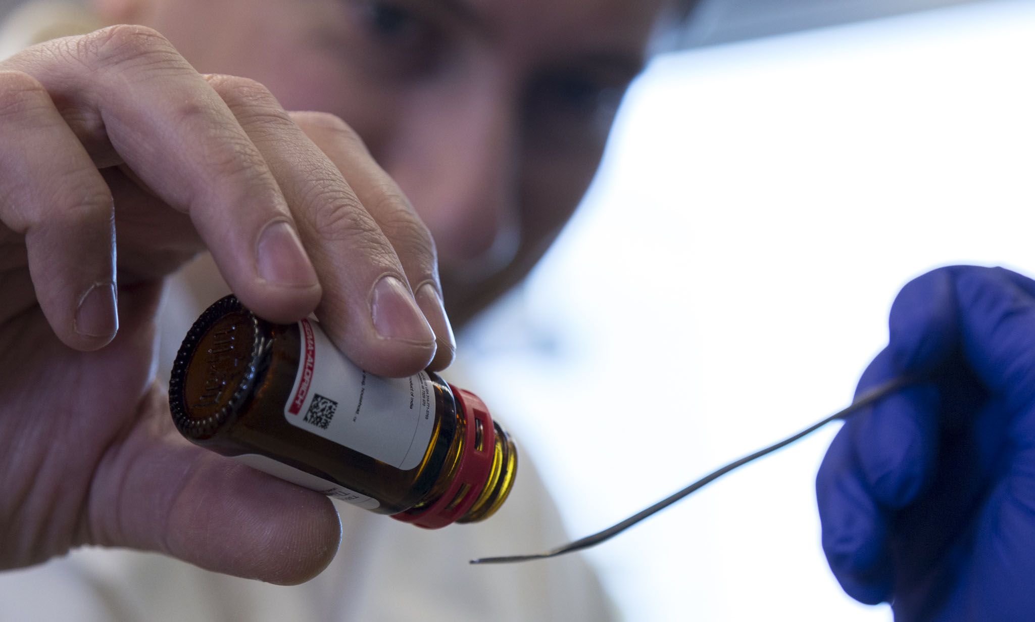 Liquid from a vial is dropped onto a small spoon.