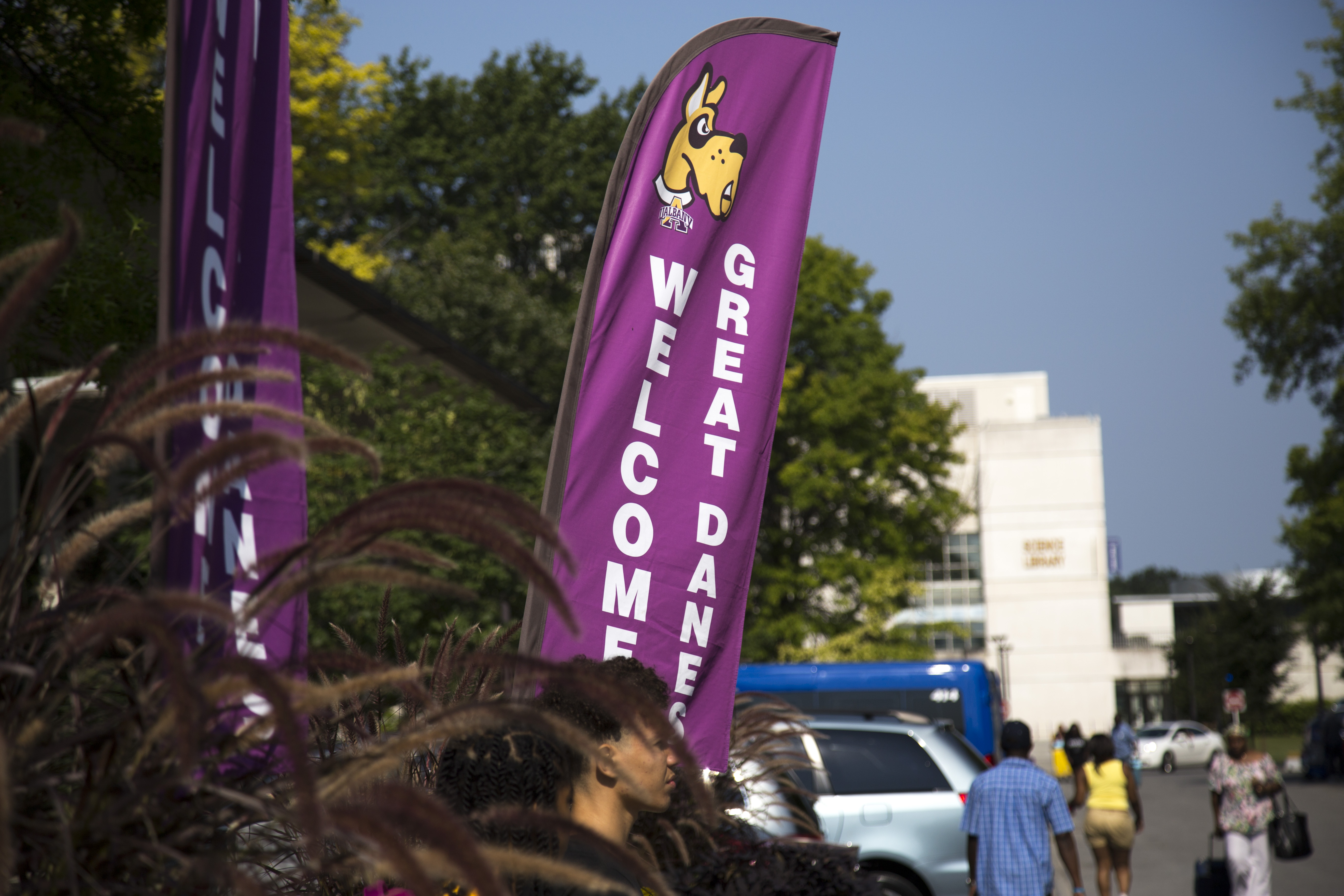 A purple "Welcome Great Danes" banner with the Uptown Campus in the background