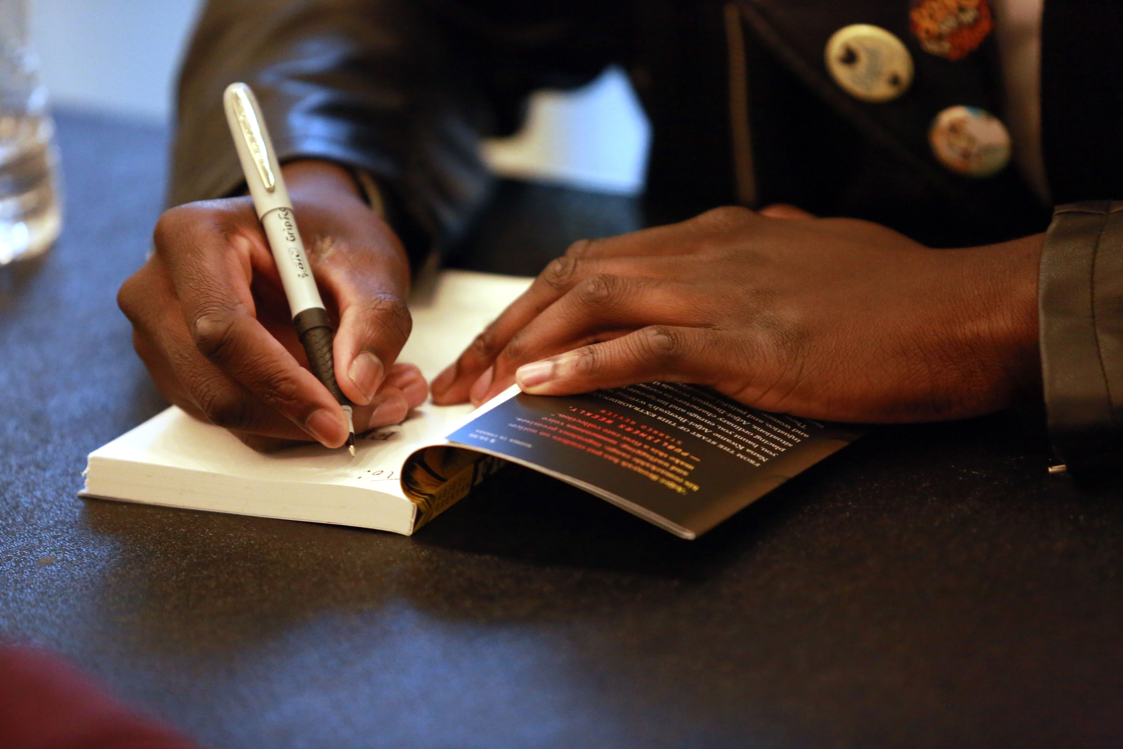 Nana Kwame Adjei Brenyah signing a book.