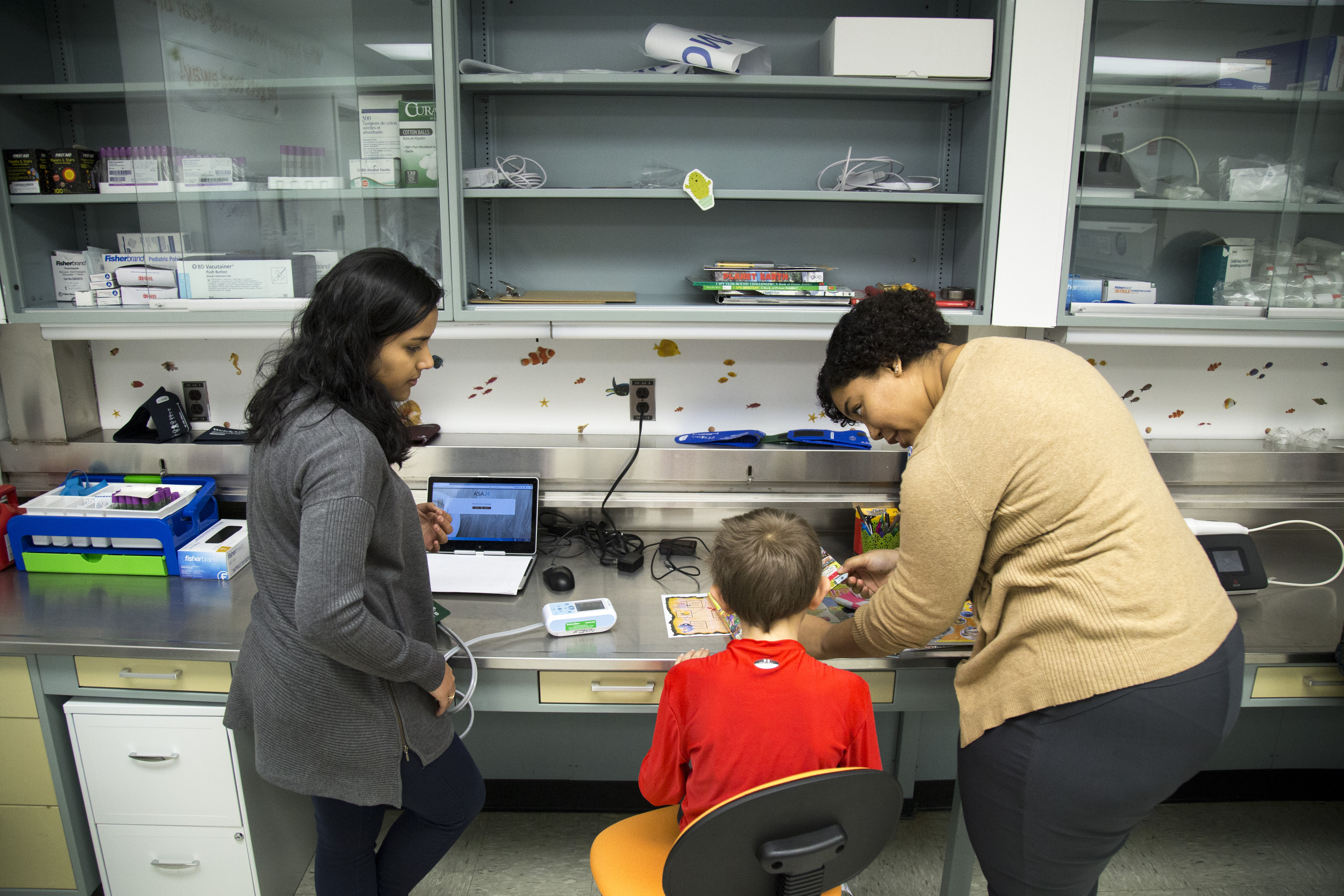Two women with a boy in a red shirt in the Upstate KIDS lab