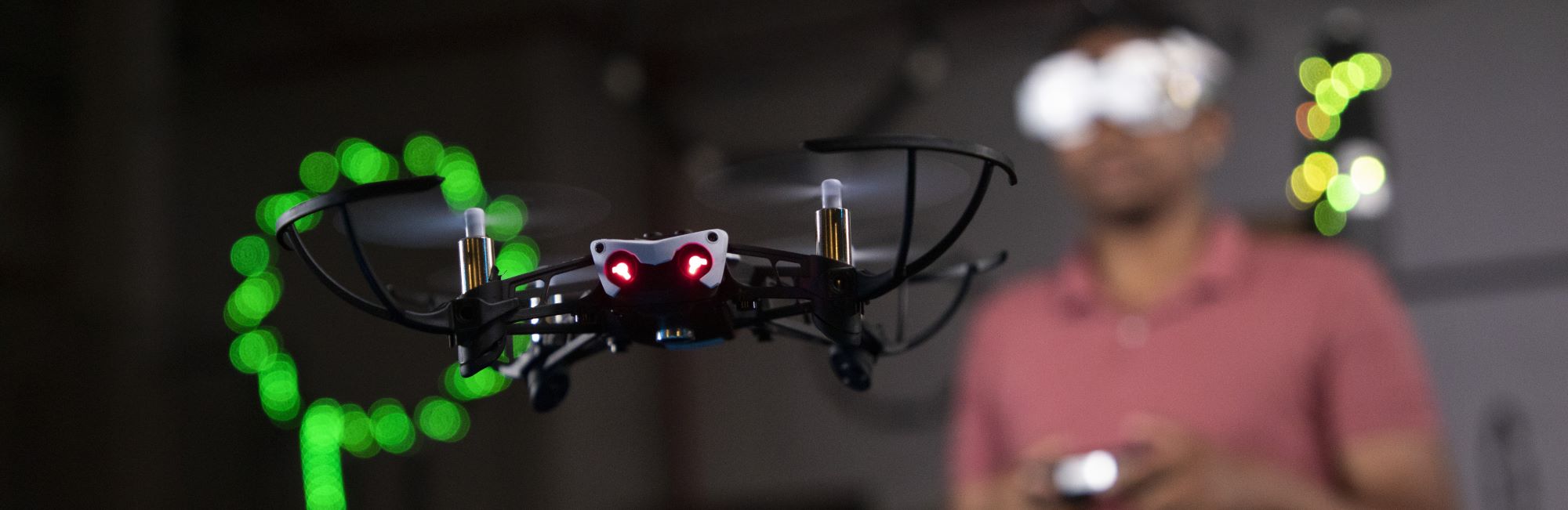 Student wearing a virtual reality headset controlling a flying drone.
