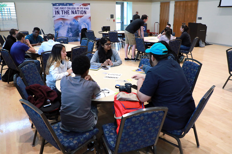 Student sit around a table during a design challenge as part of CEHC's State of Grace event.