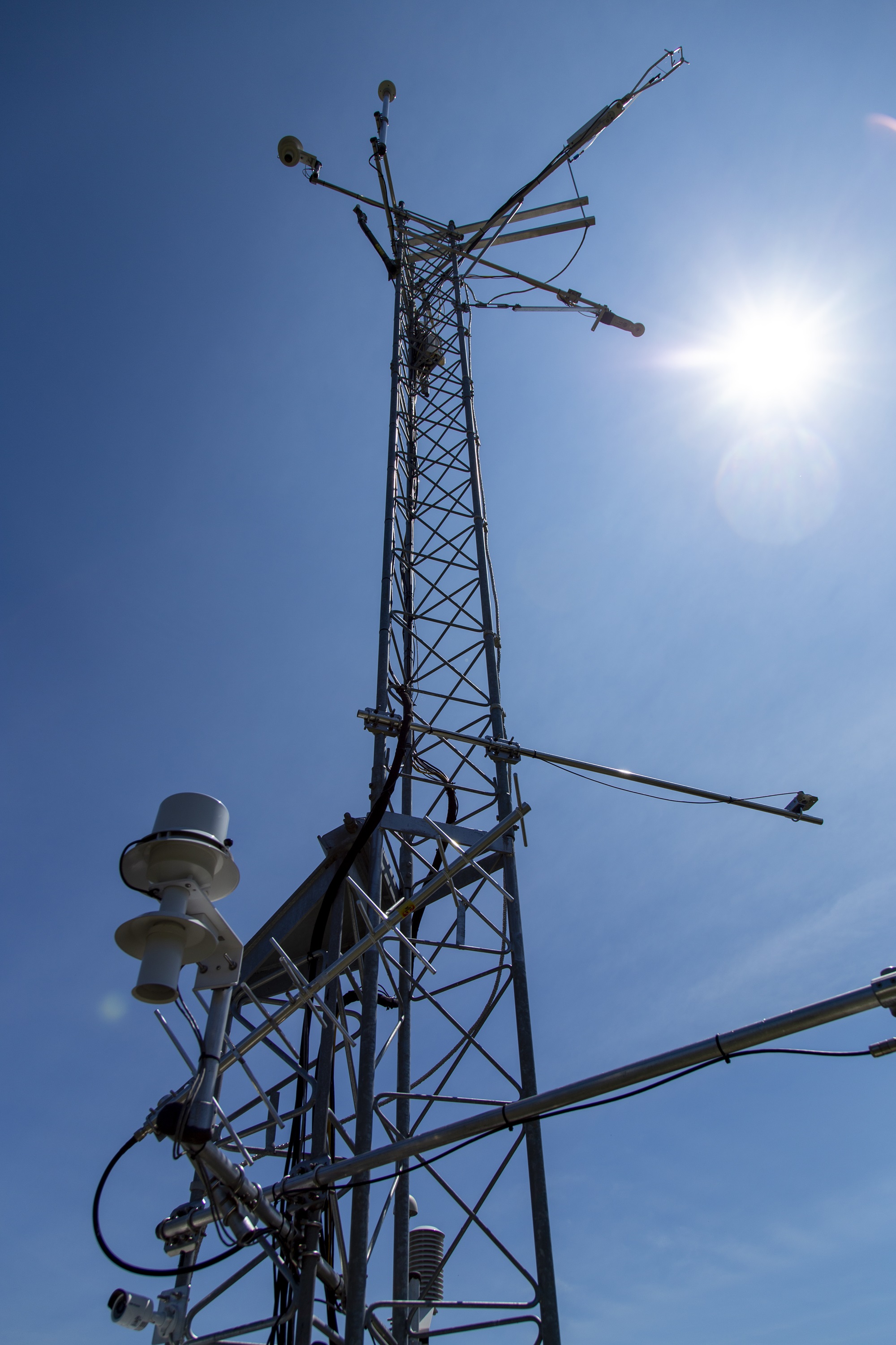 Sun reflects off a Mesonet tower on a summer day.
