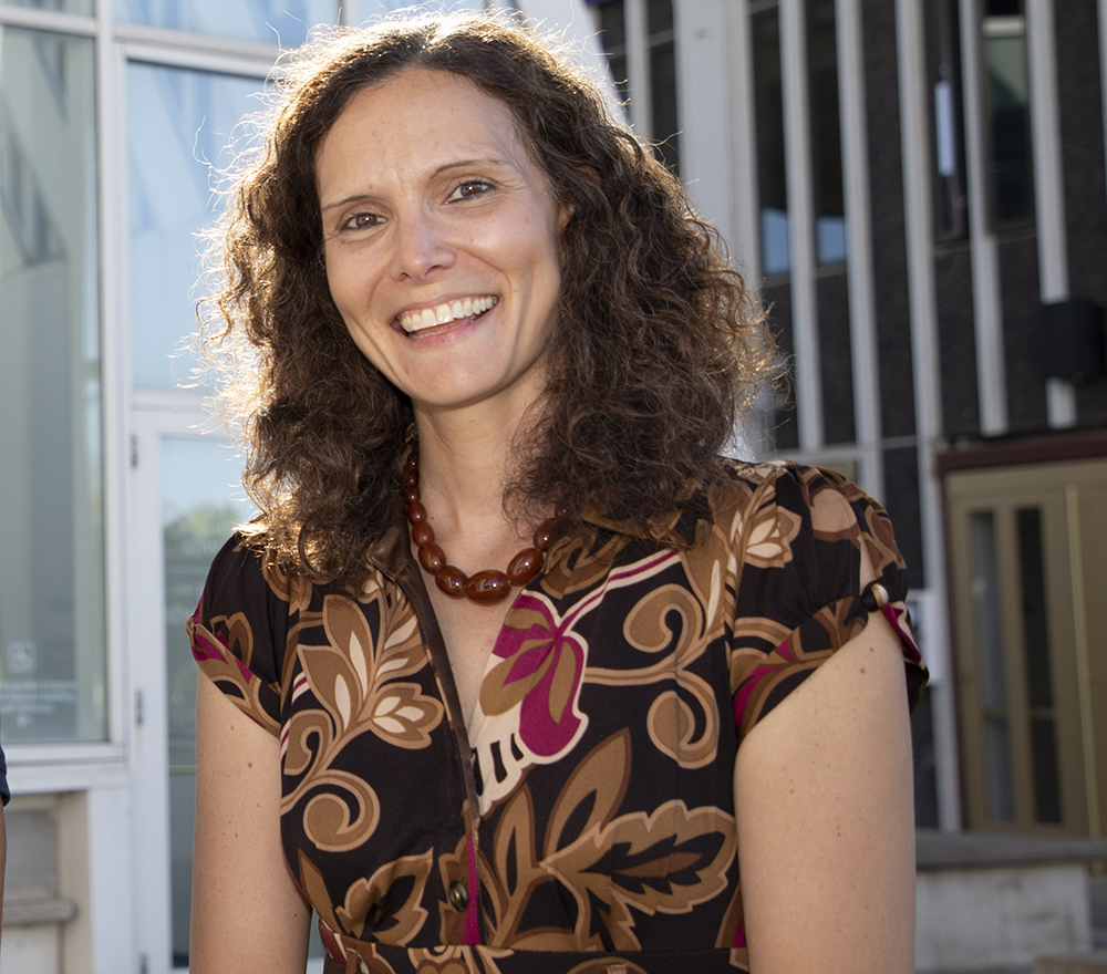 Samantha Friendman, smiling, sits on the Podium