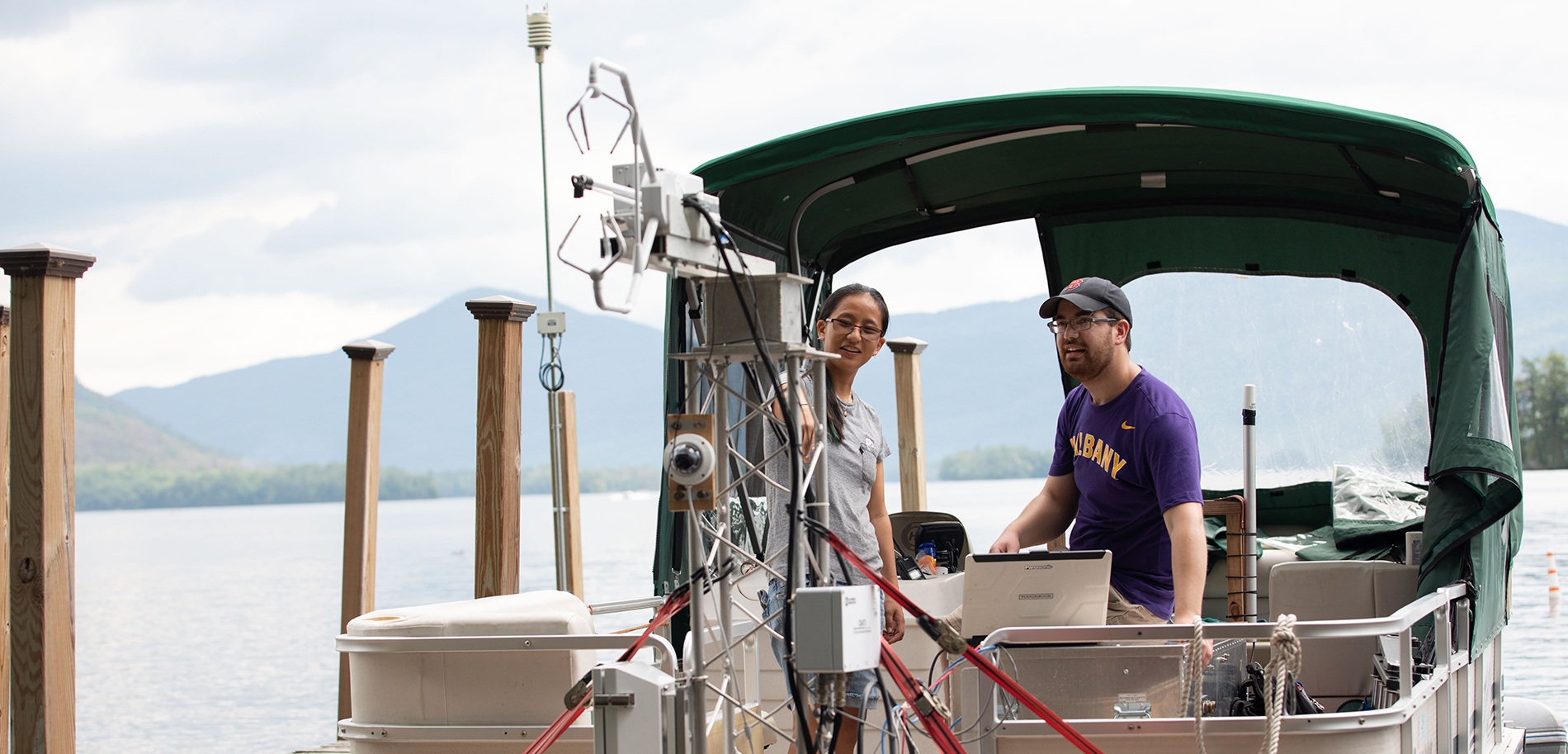 Students of the Atmospheric Sciences Research Center (ASRC), funded through $500,000 in support from the Department of Energy (DOE), works on a buoy-based flux measurement system at Lake George on Wednesday, June 30, 2021. (photo by Patrick Dodson)