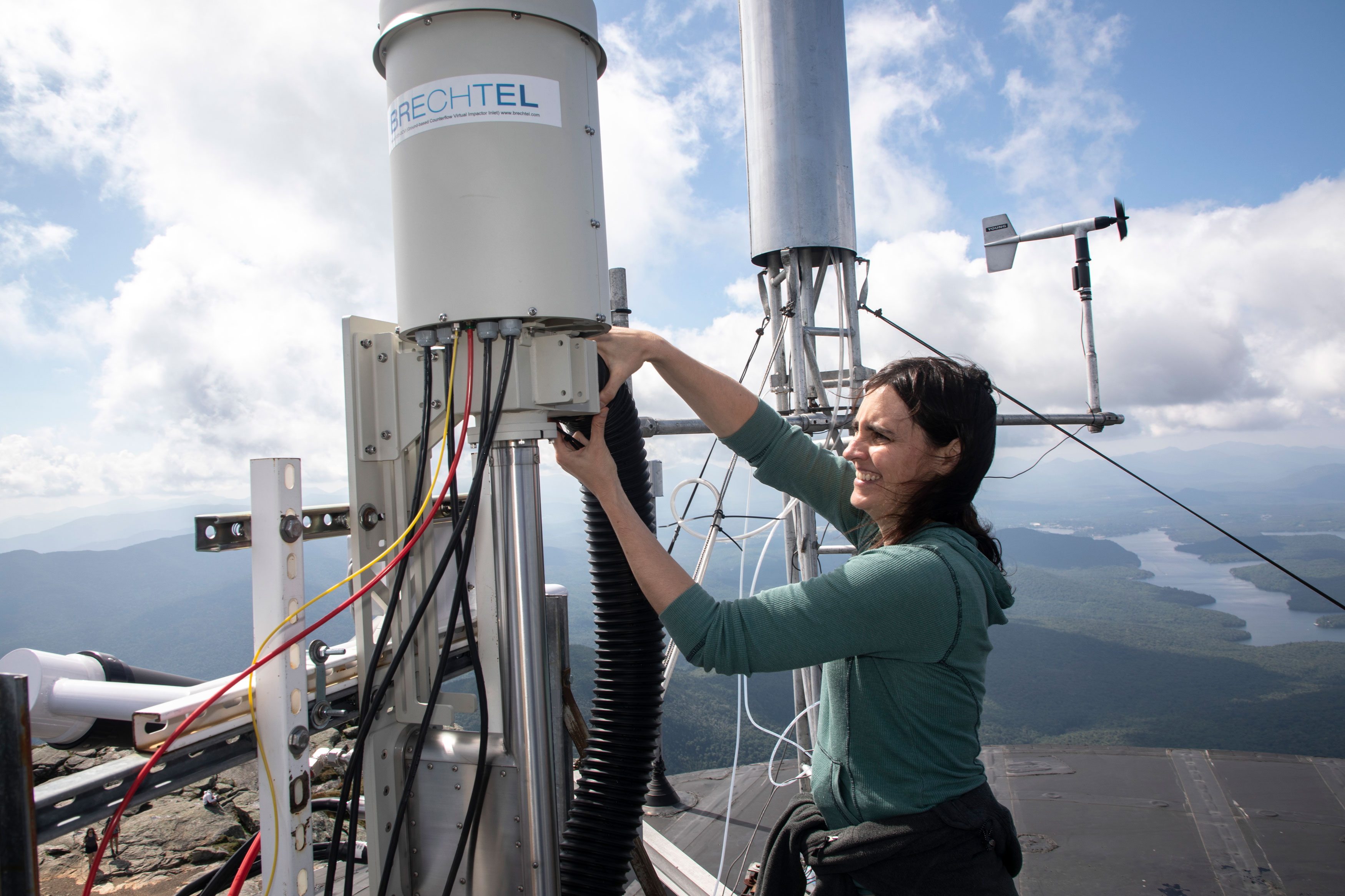 A researcher adjusts machinery for cloud water research on the summit of Whiteface Mountain