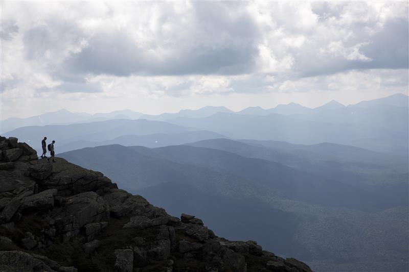Two hikers walk along Whiteface Mountain on a misty day.