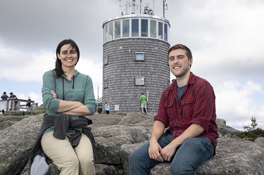 ASRC research associate Sara Lance and DAES PhD student Christopher Lawrence sit in front of the Whiteface Mountain Field Station. 