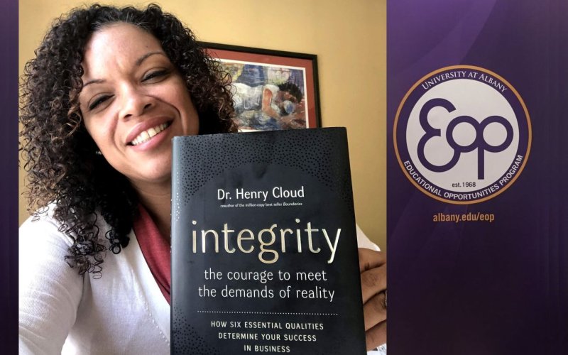A portrait of Melissa Cedeño holding the book "integrity" by Dr. Henry Cloud in the foreground. 