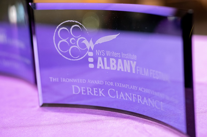 A close-up of a curved glass award honoring director Derek Cianfrance with NYSWI's Ironweed Award.