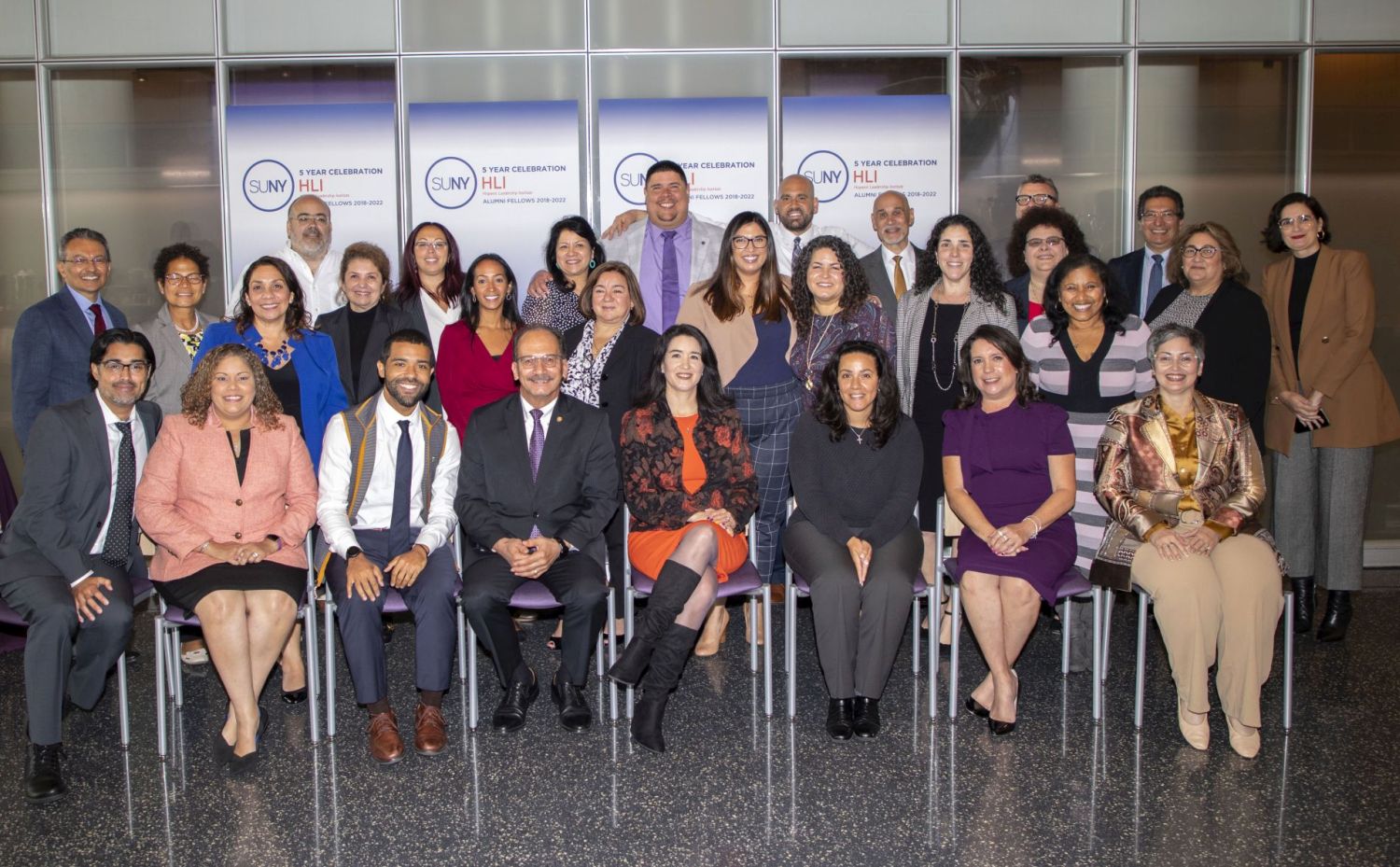 A group of smiling faculty and staff members pose together at the HLI celebration