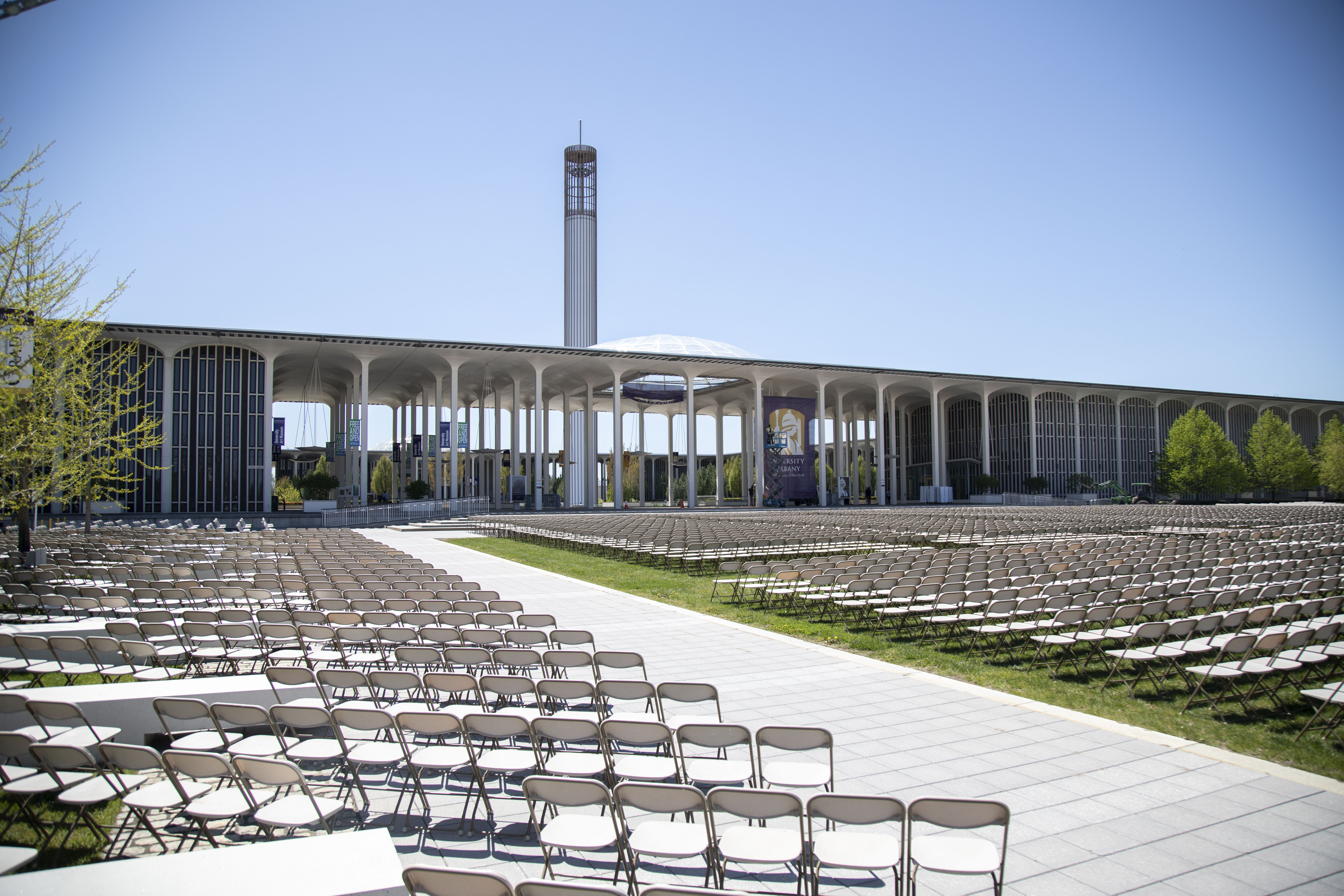 Rows of folding chairs lined on the Entry Plaza lawn of the Uptown Campus for Commencement 2022.