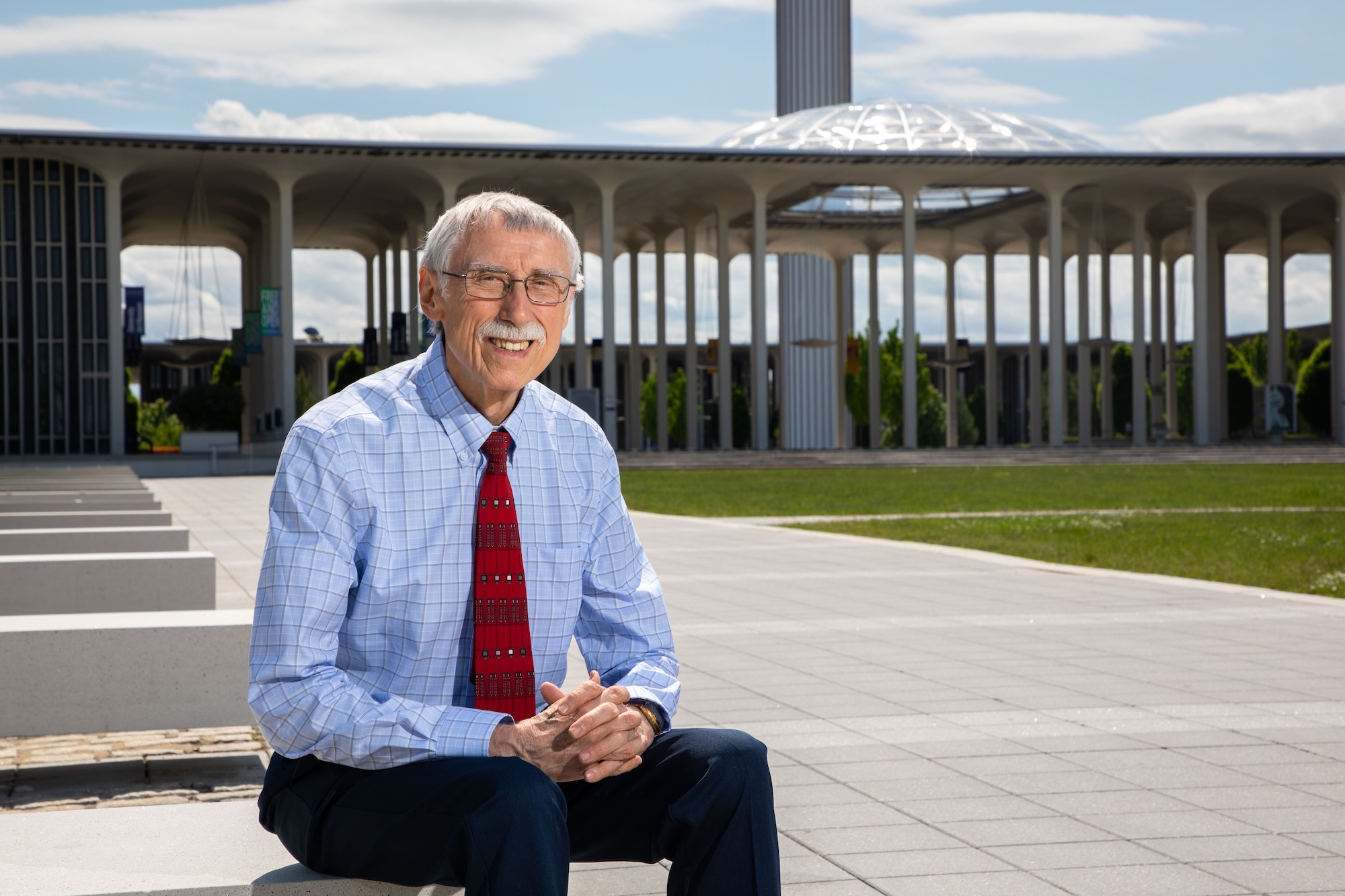 UAlbany Professor Emeritus and Collins Fellow Ray Bromley sitting in front of the podium