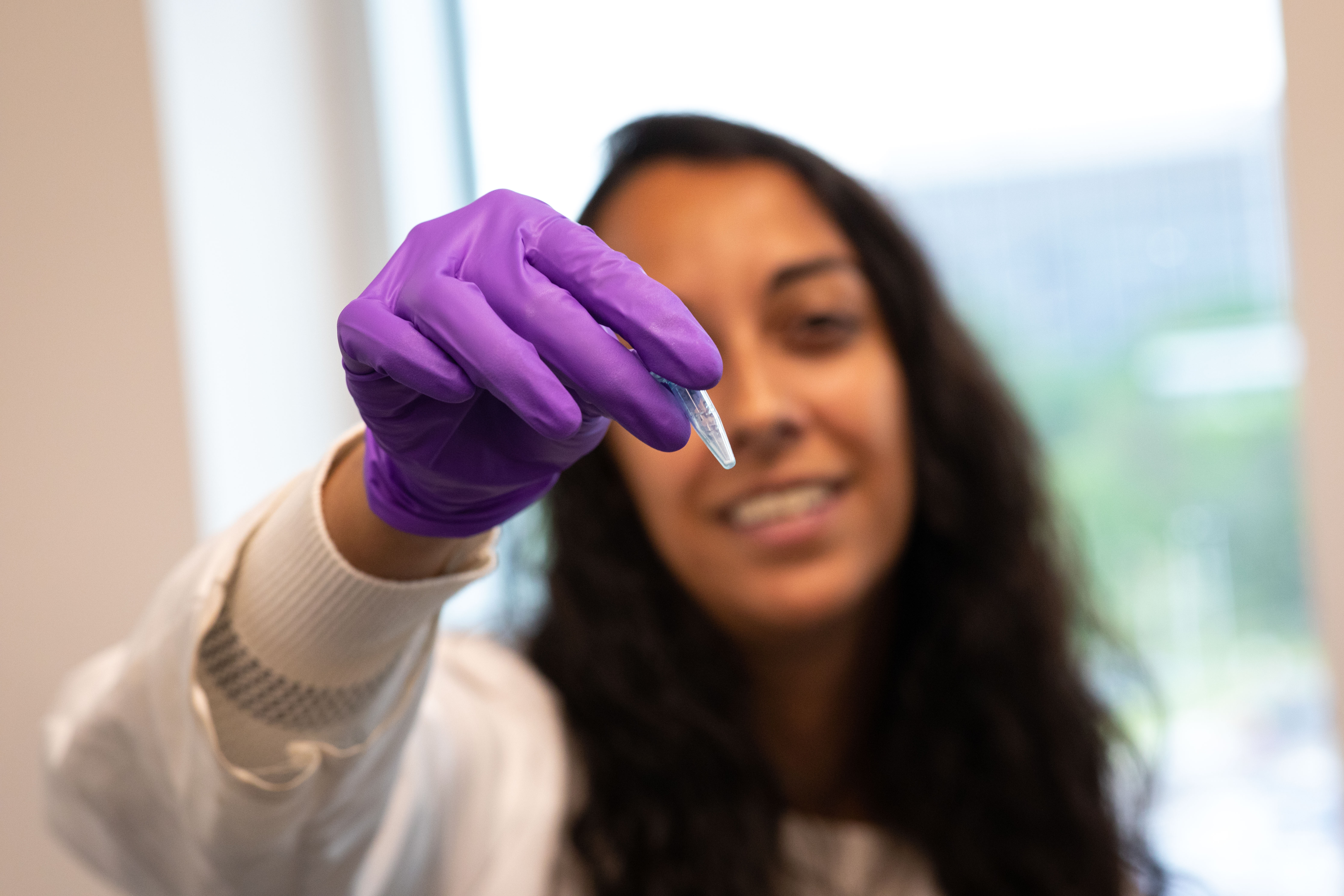 Sujata Murty holds a small vial with coral powder inside.