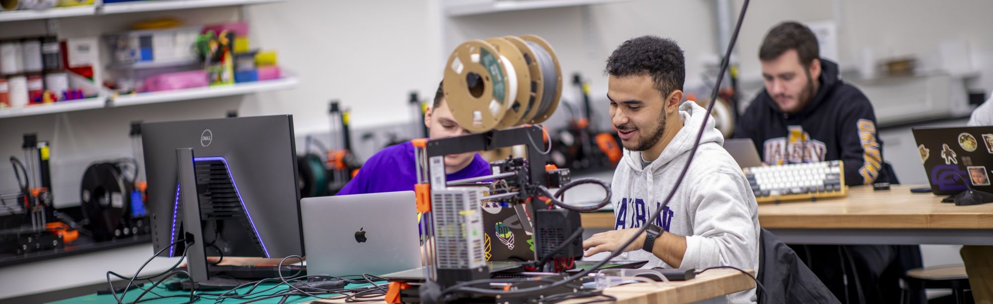 Students working together on a 3D printing project in a lab.
