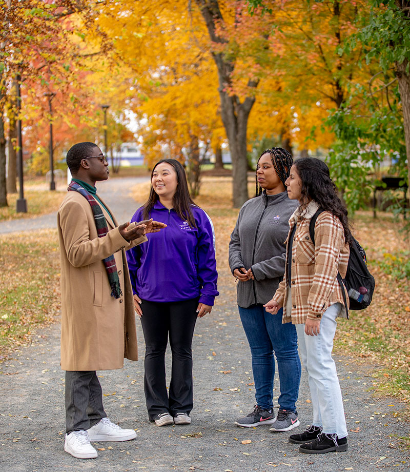 Four students talking outside on campus.