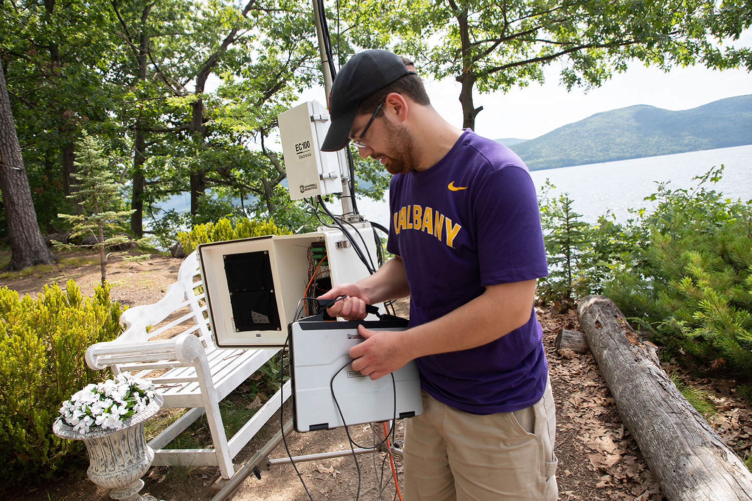 Jason Covert, a research technician at the Atmospheric Sciences Research Center and NYS Mesonet, prepares a land-based flux measurement system on Crown Island at Lake George.