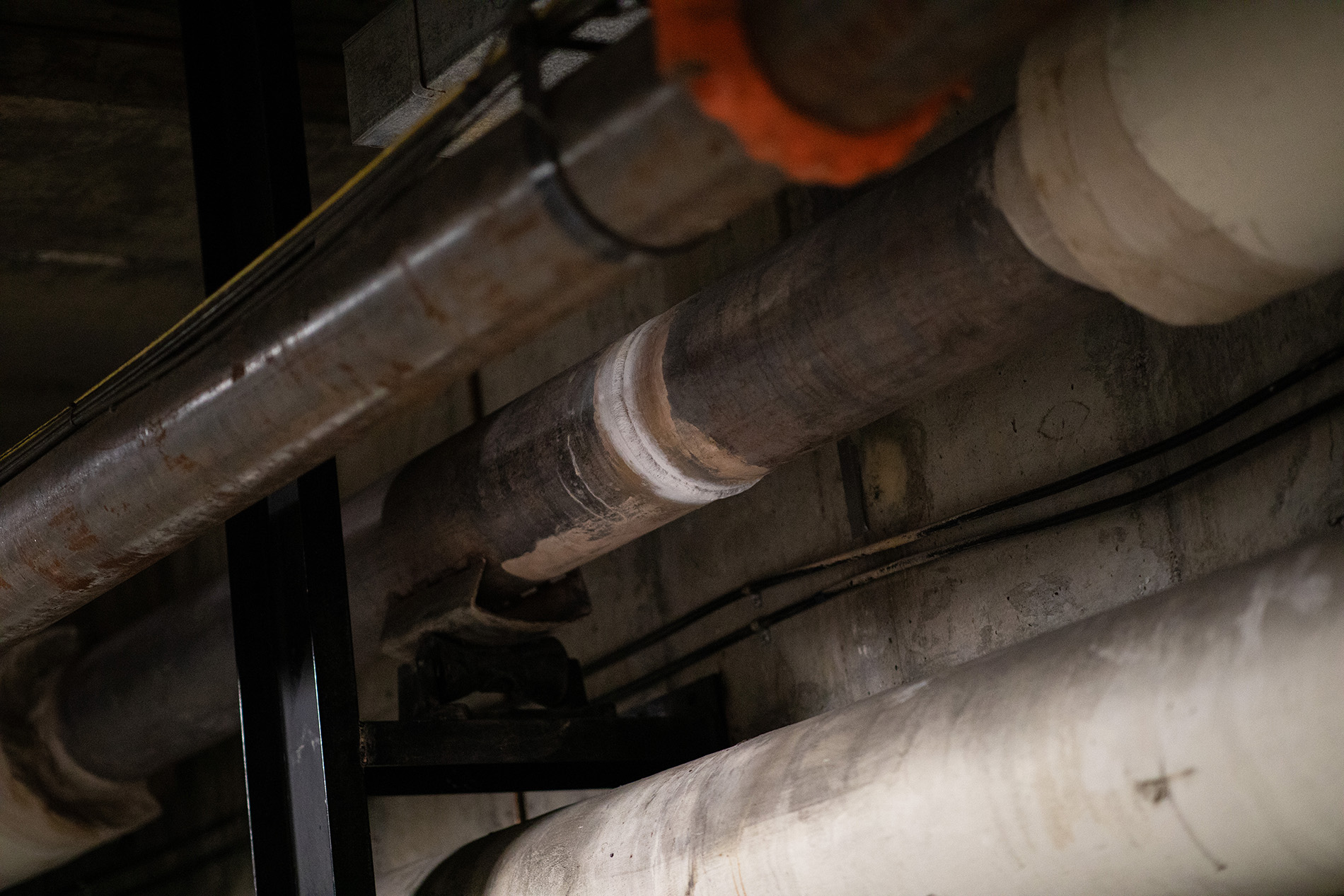 A photo of a metallic gray pipe with a a white ring showing a recent weld.