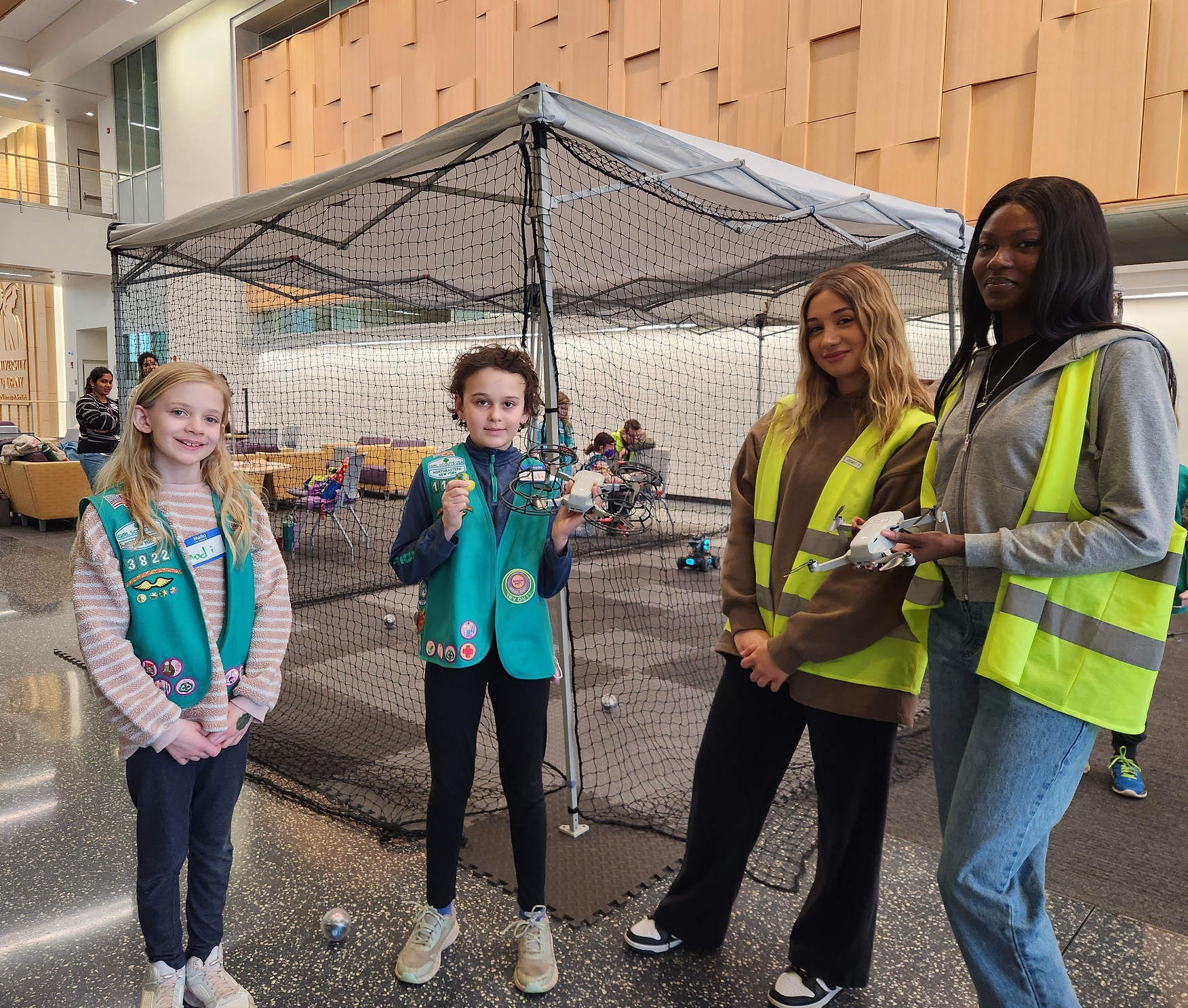 CEHC students stand with Girl Scouts in front of the drone pop-up tent at ETEC.