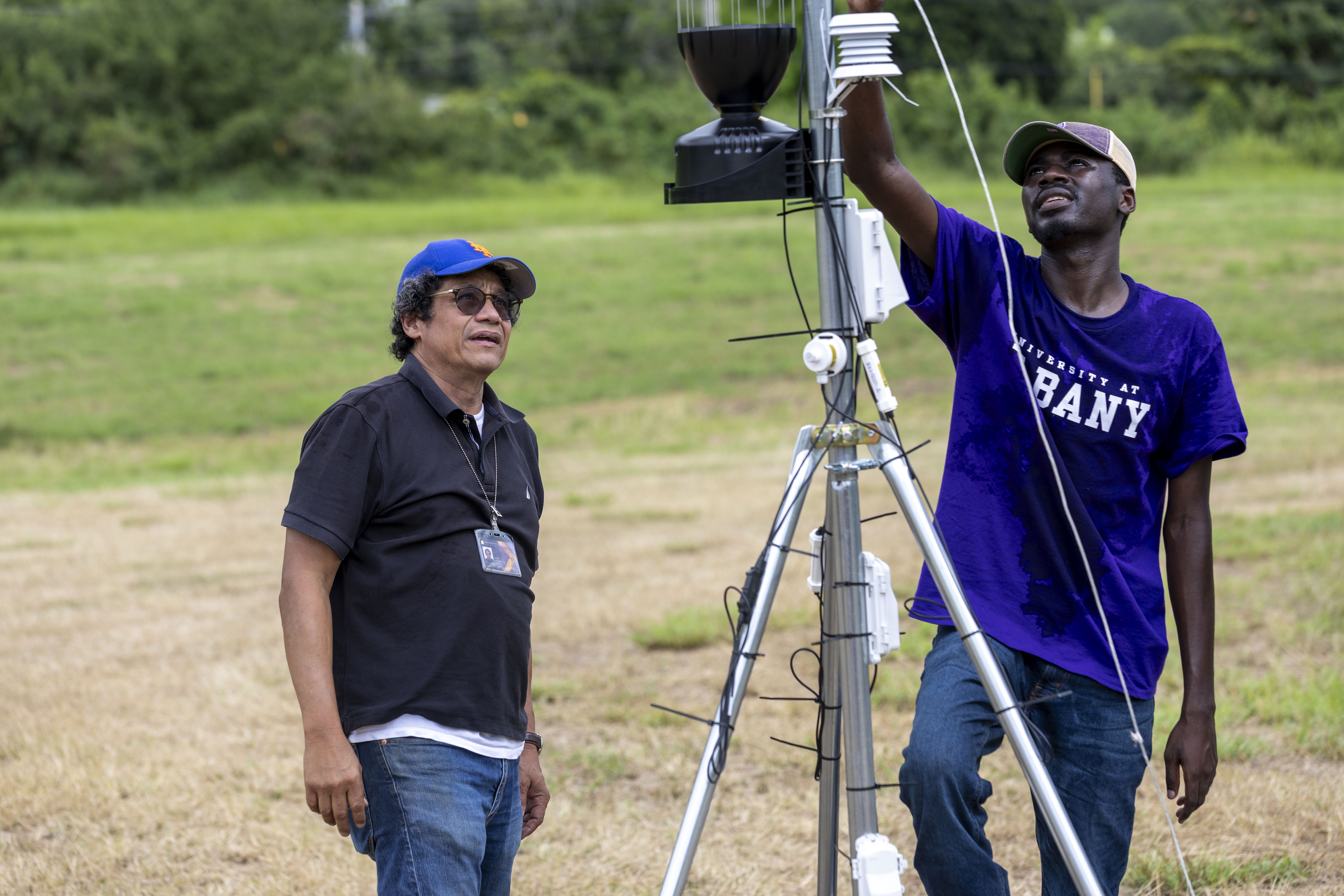 Jorge González-Cruz and Frederick Oppong stand in front of a sensor installed to monitor the safety of Puerto Rico’s transmission towers when exposed to extreme weather events.