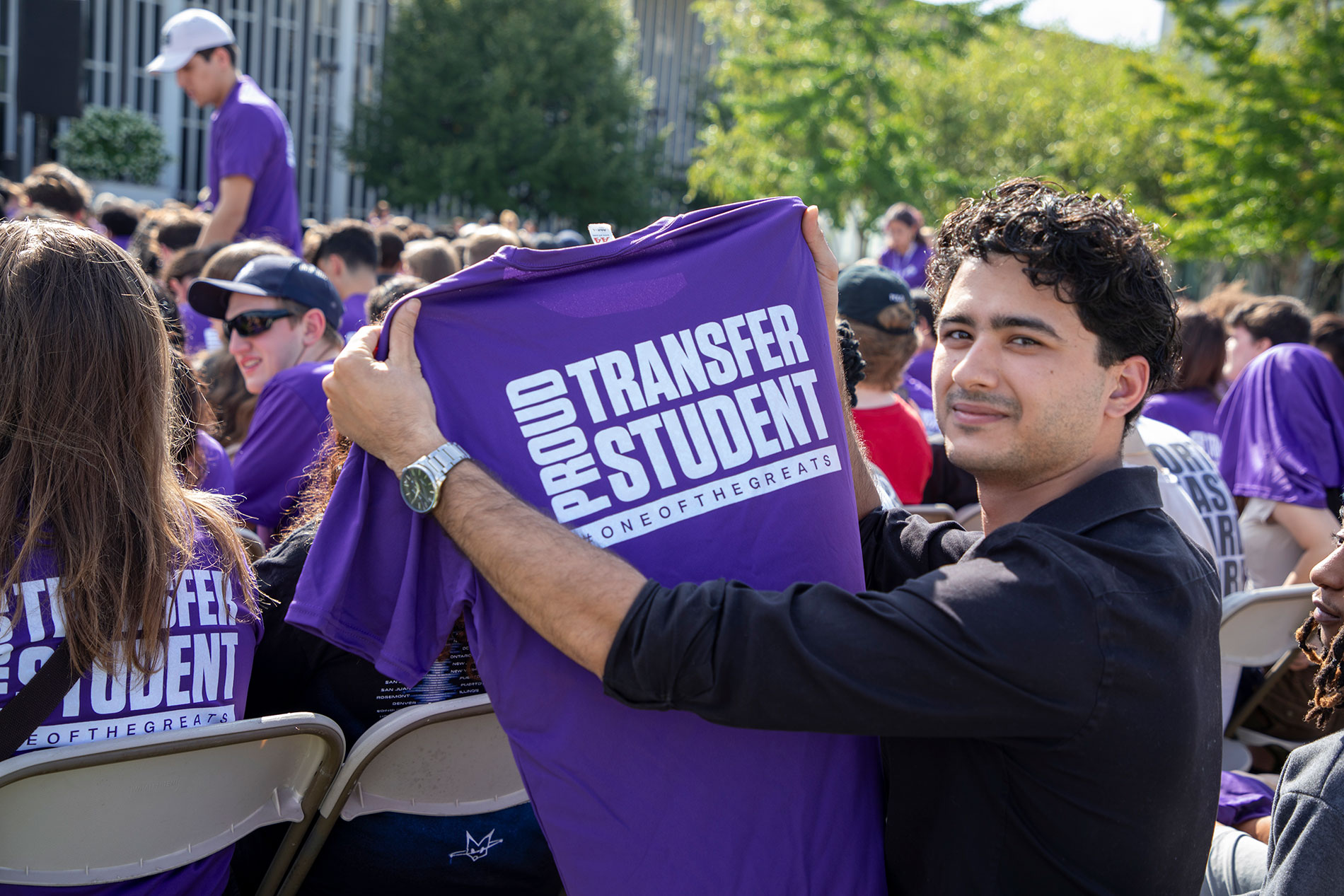 Student holding up Proud Transfer Student shirt at Convocation.