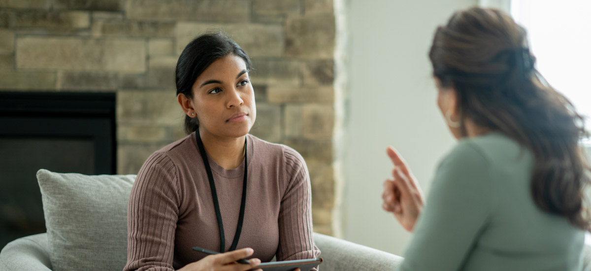 A smiling counselor meets with a client.