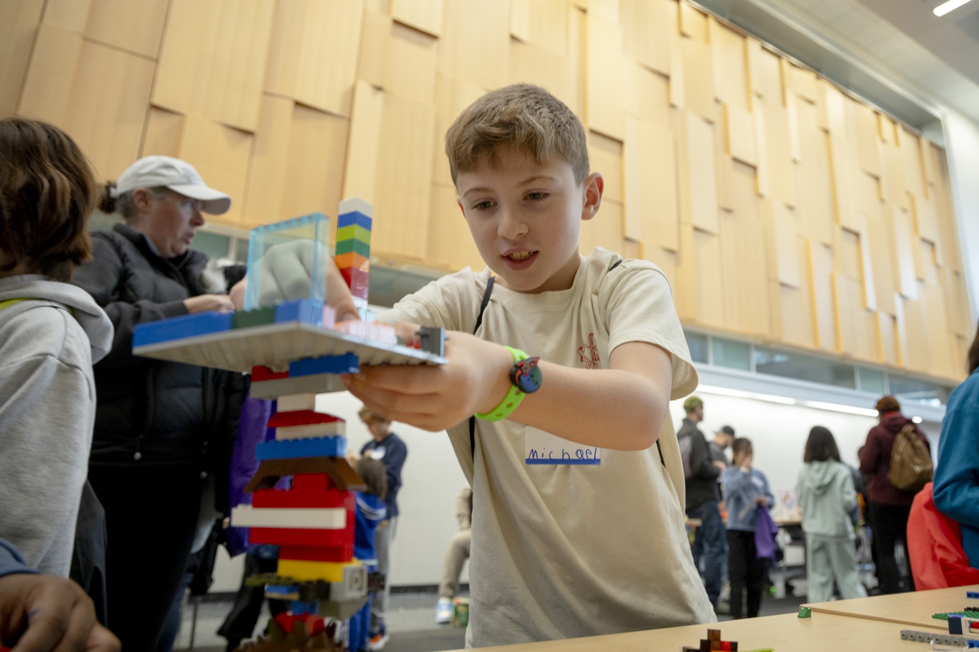 A child builds a Lego protection tower on a table at the ETEC atrium.