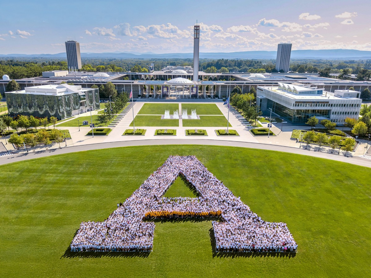 Hundreds of UAlbany students stand in the shape of a large A on the field of Collins Circle