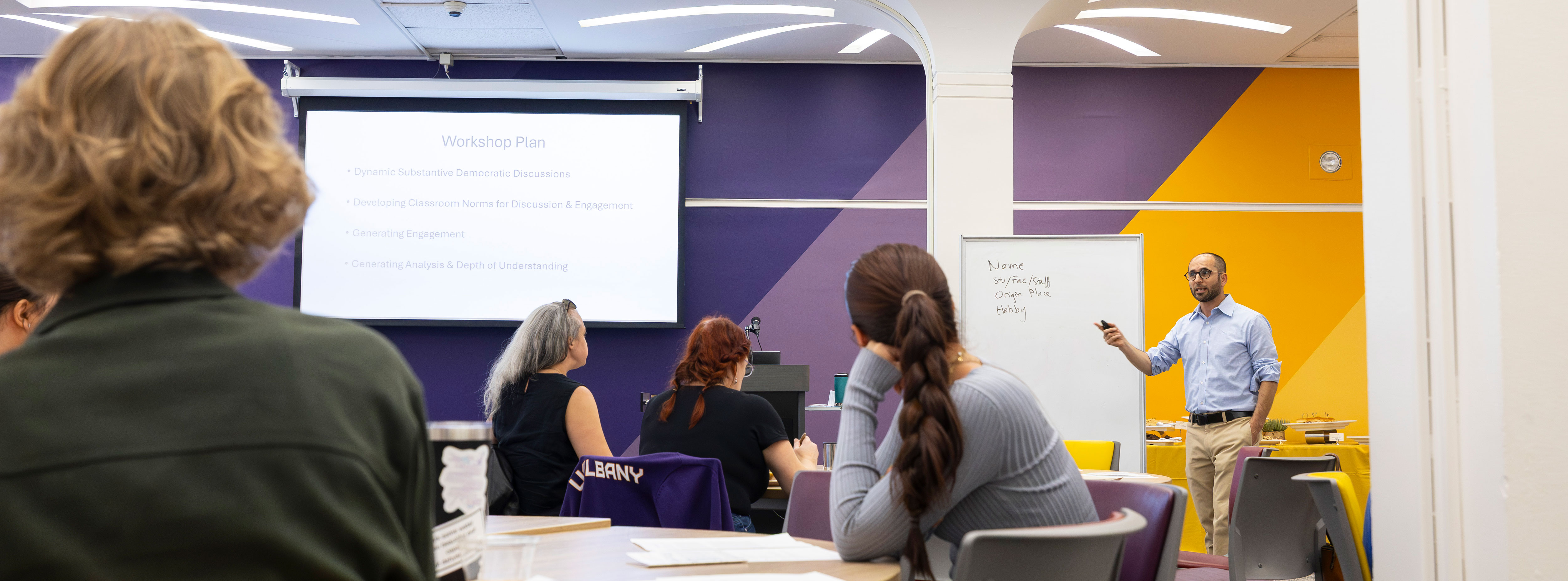 An instructor lectures a classroom full of students.