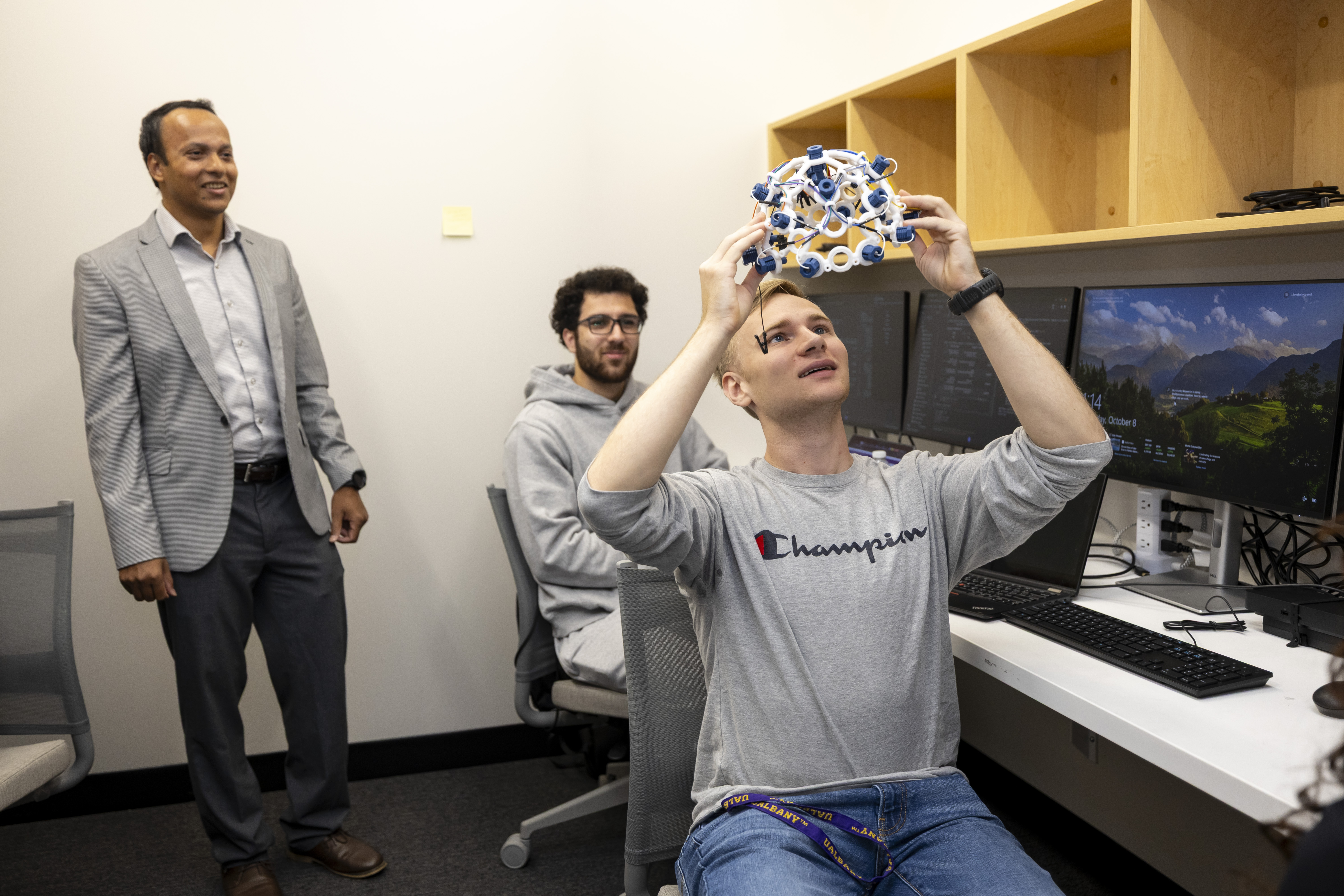 Stephen Gravereaux holds up an EEG headset, which is used to detect and record the brain's electrical activity.
