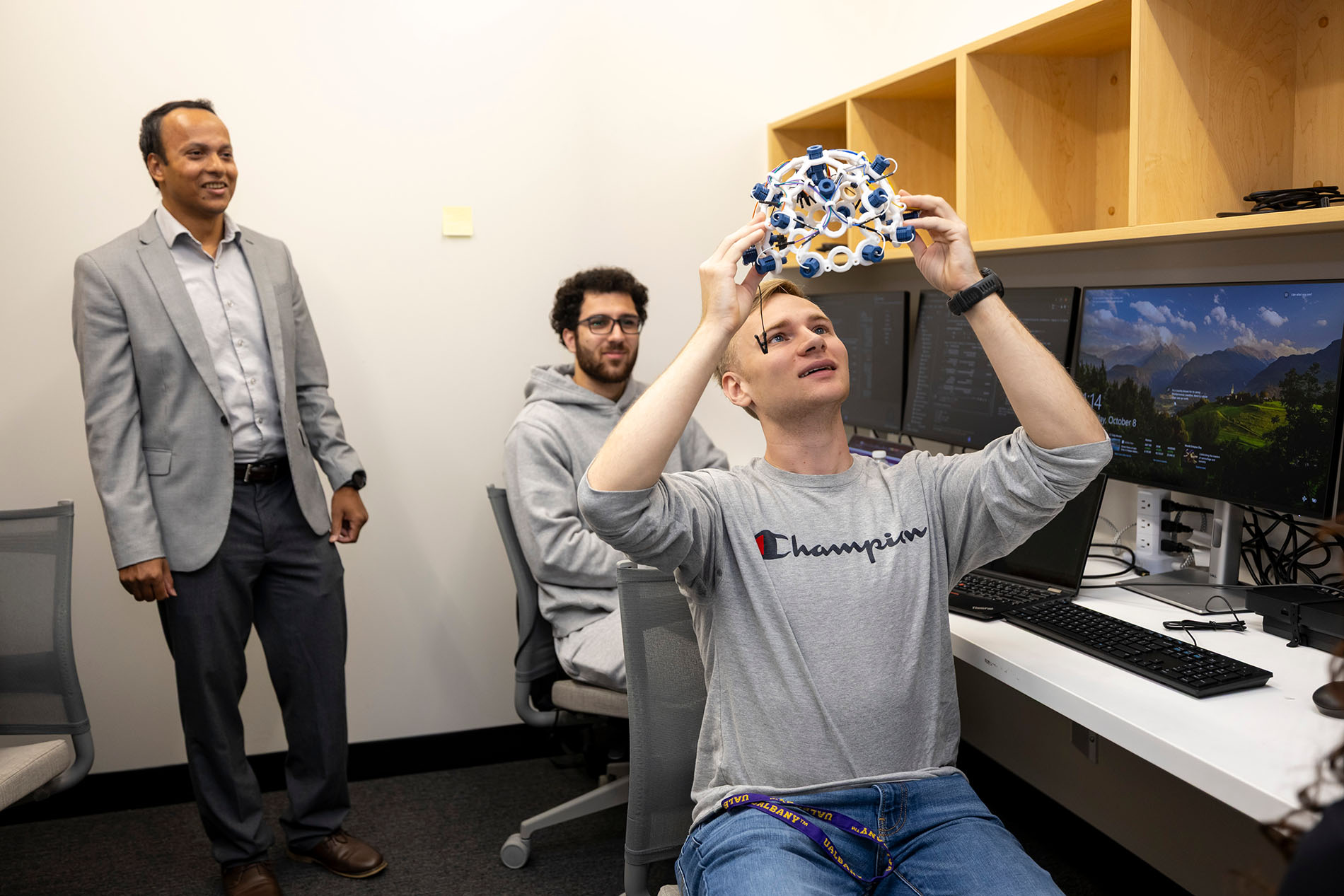 Stephen Gravereaux holds up an EEG headset, which is used to detect and record the brain's electrical activity.