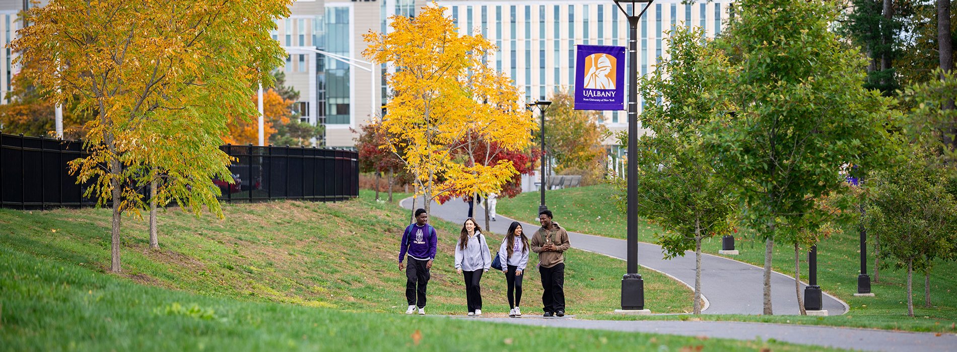 Four students walking on the purple path by the ETEC building.