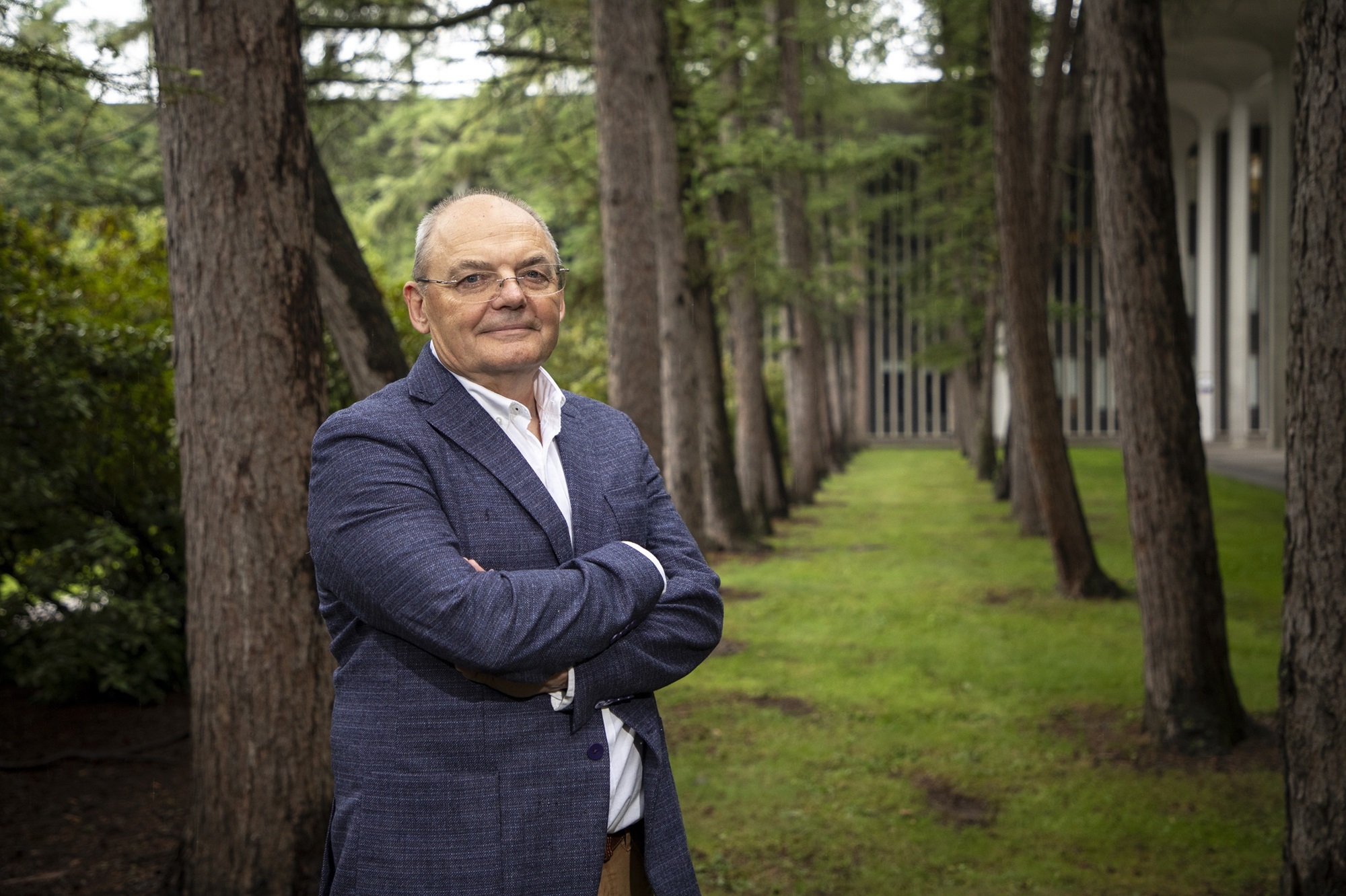 Andrei Lapenas stands with trees in the Academic Podium courtyard.