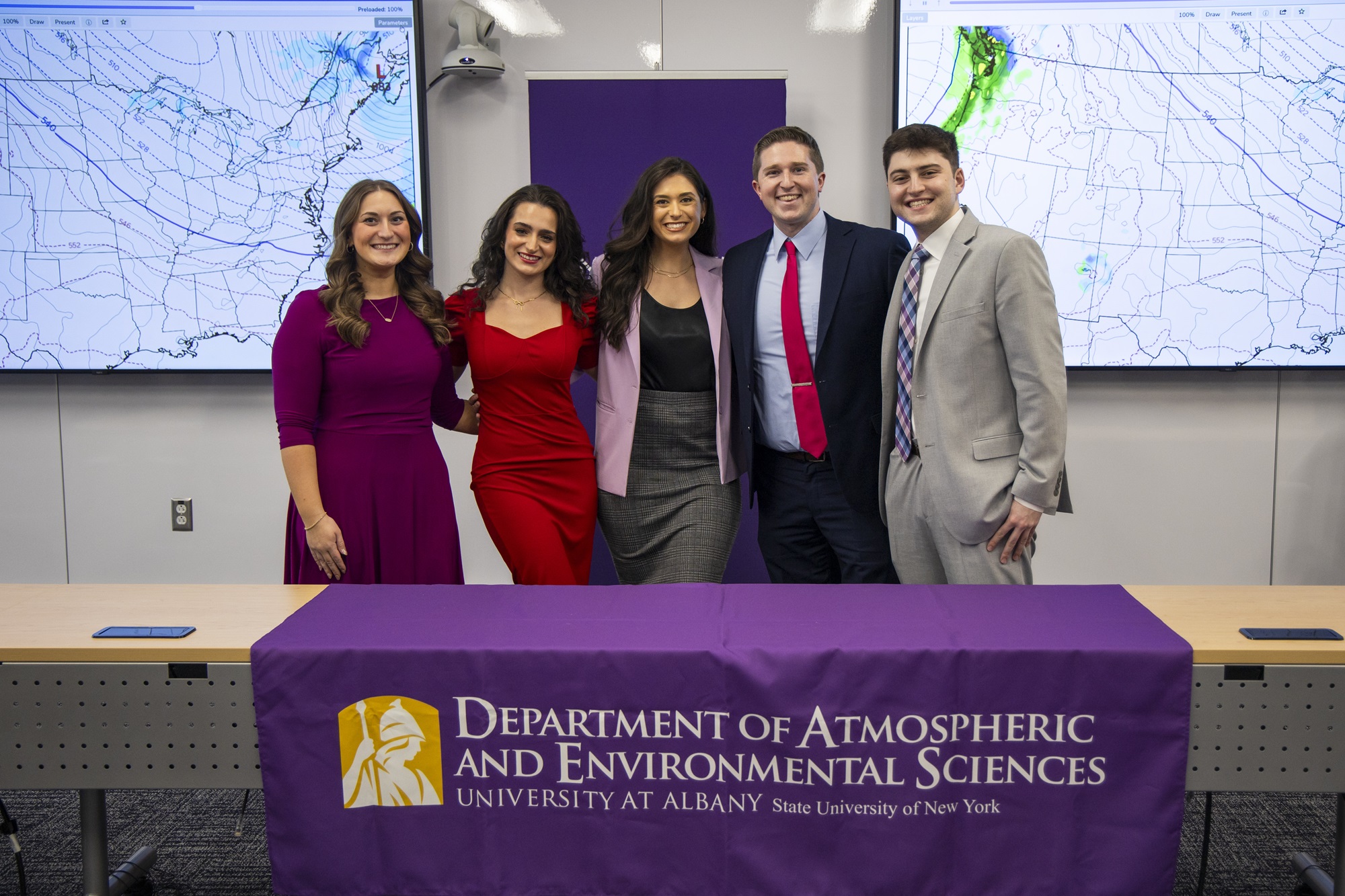 UAlbany roundtable panelists take a photo together in front of a Department of Atmospheric and Environmental Sciences table covering.