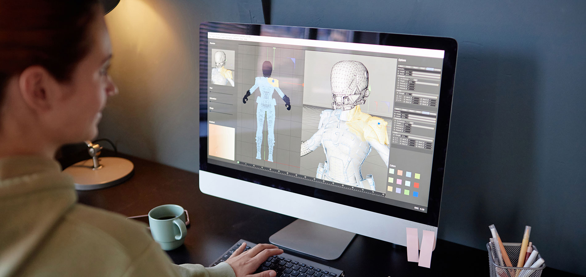 A game designer works on a character model on a computer.