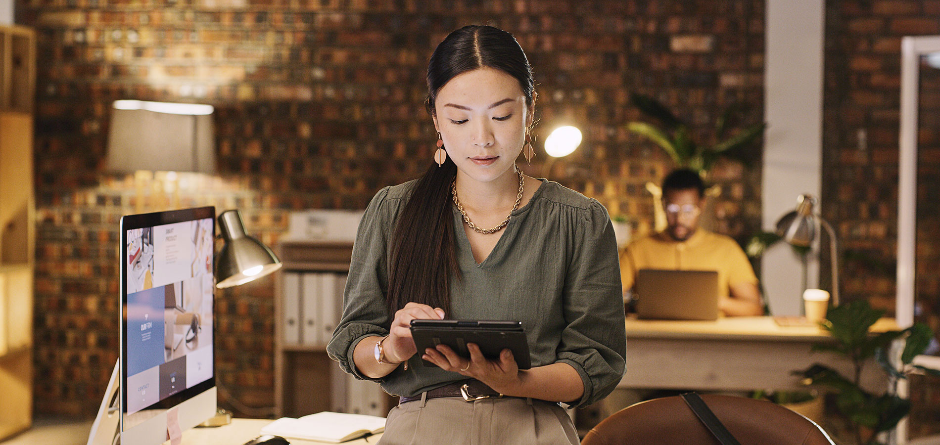 A social media manager works on a tablet in an office.