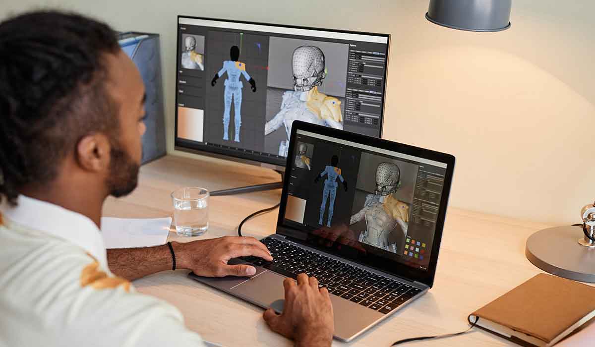 A 3D game artist develops a character on a laptop.