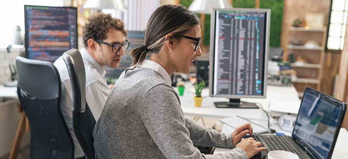 Two cybersecurity professionals working in an office.