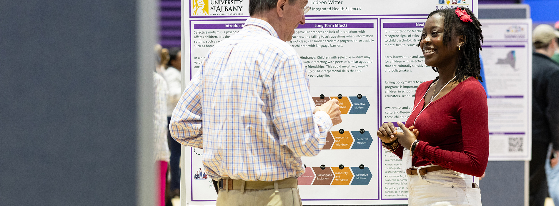A student presenting their research poster to a faculty member at UAlbany Showcase.